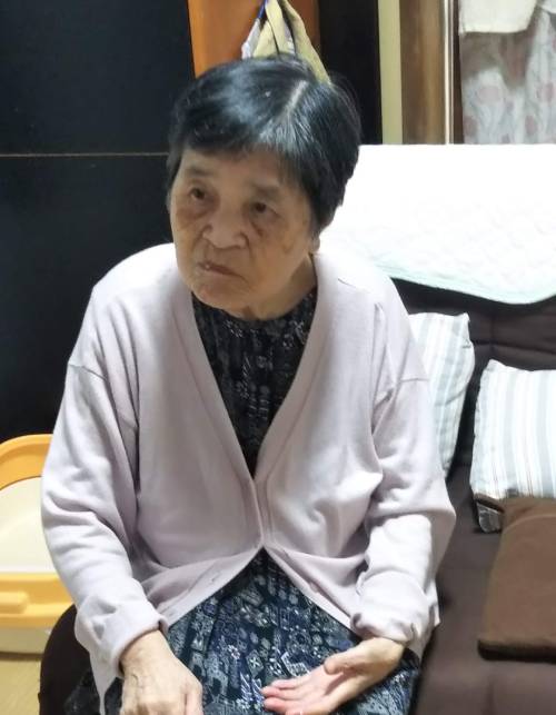 疲れたような顔でソファに座っている母の画像